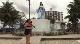 People pray and light candles at the statue of Iemanja in Praia Grande, Brazil