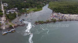 Tourists have fun in the waters of the Guarau River in Peruibe in Brazil