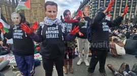 Pro-Palestine protesters pose with Rishi Sunak and Benjamin Netanyahu face masks and bloodied hands
