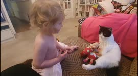 Little girl doesn't want to share her toys with the cat! They're mine...