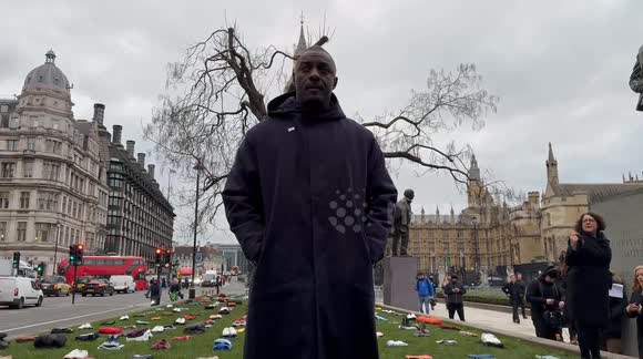 Idris Elba stands in Parliament Square with clothing respresenting victims of knife crime in the UK