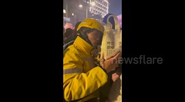 Courier has trouble finding a customer in a crowd celebrating New Year on the street of Kaifeng, China