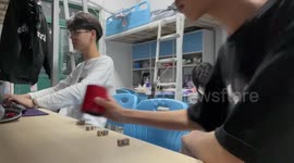 Student shows off flashy dice-rolling skills using cup