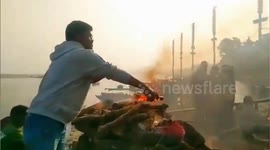Man offers liquor and cigarette on dead father's funeral pyre