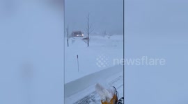 Snowplow pushes through thick pile of snow caused by severe storm in Buffalo, New York