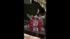 Dog snow sculpture with fairy wings and sunglasses sit in front of school in China