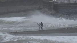 Locals on beach at Aberystwyth watch Storm Isha slam into Wales