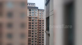 Window cleans windows on 32nd flood apartment window ledge