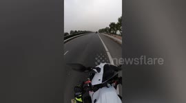 Motorcycle rider dodges falling cargo on Chinese highway