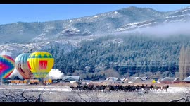 An elk herd, a hot air balloon launch, an historic steam powered locomotive amidst snow capped mountain cliffs