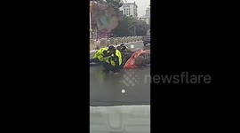 Traffic police officers slip while helping fallen citizen in icy conditions in China