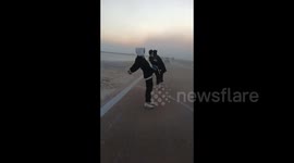 Three Men Lean Against Strong Winds to Avoid Falling Down in Yuncheng, China