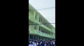 Cat hanging from phone lines caught by pupils with outstretched blanket