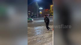 Hilarious moment man slips on icy road in China