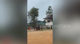 Kids swing around low-budget DIY carousel made from old umbrella tent