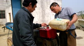 Man refuels tractor while smoking