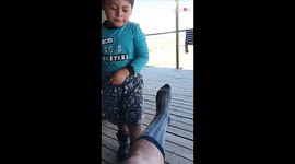 Boy is engulfed in disgust while taking off grandad's socks