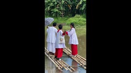 Altar servers cross river while carrying baby Jesus statue
