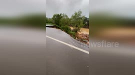 Car dragged into hole when road collapses into river