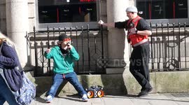 A lone street protester raps confusingly until switched off then hand cuffed by a police constable. King st, Truro, Cornwall, UK