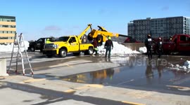 Snow Plow Operator Unharmed After Equipment Tips Over Parking Ramp in Madison, USA