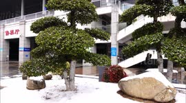 Workers clear snow at the square in front of Yichang East Railway Station in China