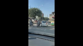 A Scooty rider seen pushing a breakdown car with his legs on Noida road