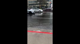 To mad or not to mad: Woman's dilemma as joyous man drives on sidewalk during rain