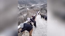 Tourists defy snowy weather to climb China's Great Wall despite slippery conditions