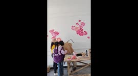 Creative Display: Chinese Woman Showcases Artistic Talent on Family Visit