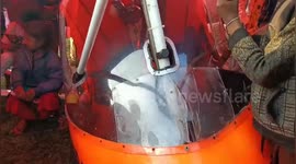 Locals pose with micro aircraft that crash-landed in field in east India