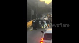 Men rescue an overturned car on the side of the road in Sichuan, China