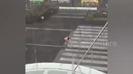 Playful local does Tai Chi poses on street during rain