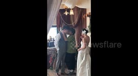 Photographer committed to his craft shows newlyweds how to pose correctly