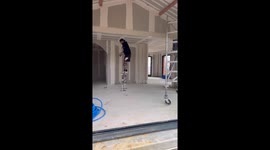 Worker on Stilts Shows How to Pick up Dropped Tool
