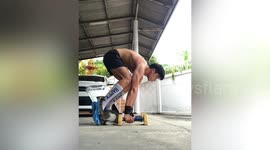 Pet cat assists owner while he exercises in driveway