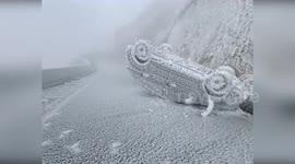 Car freezes on mountain road following overturning accident