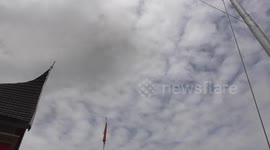 Moment volcanic ash from Indonesian volcano eruption flashes across the sky then falls onto the lens