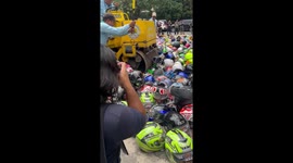 Road roller crushes hundreds of confiscated motorcycle helmets in the Philippines