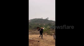 Chicken farmer banging on two metal pot lids  in Quanzhou, China