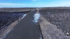 New road to Blue Lagoon being built on top of new smoking lava just six days after it was flowing over the old road