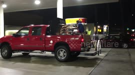 Man plays Purple Rain drum riff in the back of a truck at a petrol station