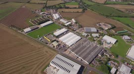 Aerial shot of factory buildings, warehouses, tracking into individual warehouse
