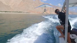 Hang glider makes extremely low pass near boat