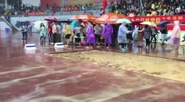 重庆一高校雨中举行运动会 学生扑泥地跳远变“跳水”