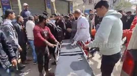 Palestinian medics transport injured people from Al-Bureij camp, Gaza