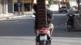 Awesome motorcycle rider balances dozens of egg crates during deliveries