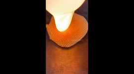 Witness the spellbinding fusion of hot glass against nature's honeycomb sweetness