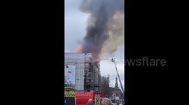 Spire of Denmark's historic stock exchange collapses as building is engulfed by fire