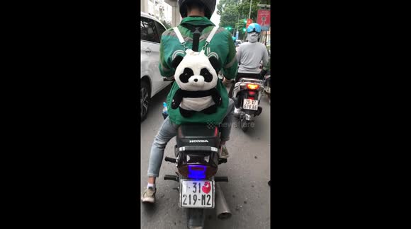 Oh! This super cute man was discovered riding a Grap motorbike wearing a panda-shaped backpack on a crowded street in Vietnam